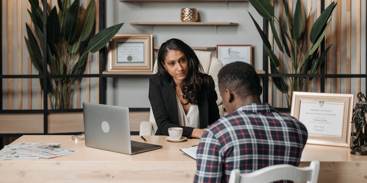 Professional woman conducting a consultation meeting with a client in an office setting, discussing employment matters and workplace rights that are protected by UK minimum wage legislation for workers across all industries.