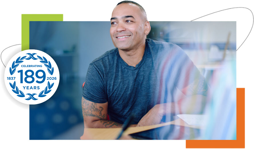 Confident professional smiling while seated at a desk in a contemporary office environment